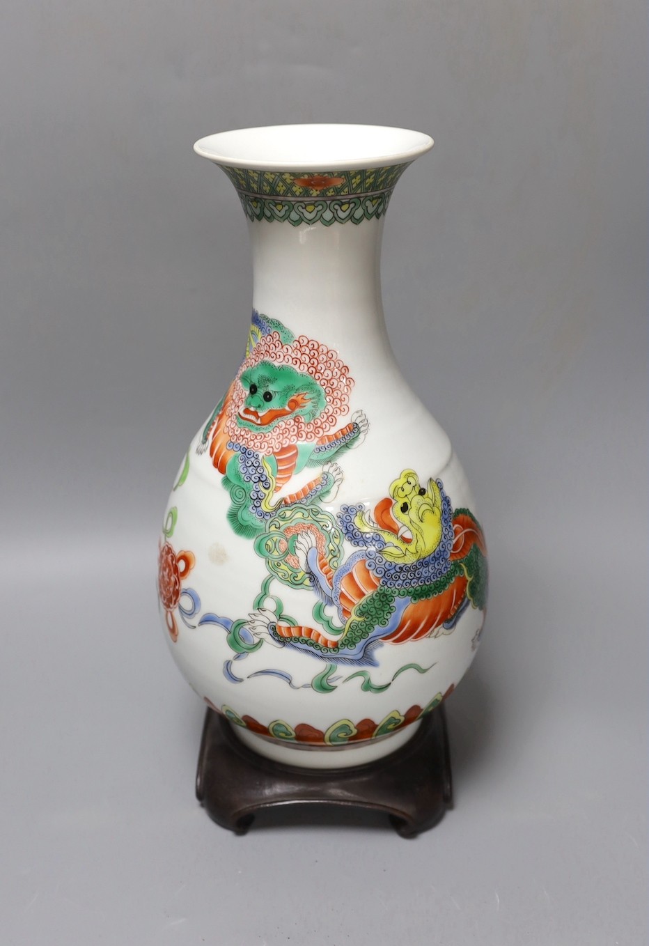 A Chinese famille verte pear shaped ‘Buddhist lion’ vase, on stand, 32 cms high not including stand.